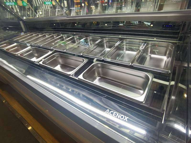 Cubetas de acero inoxidable instaladas en una vitrina para gelato